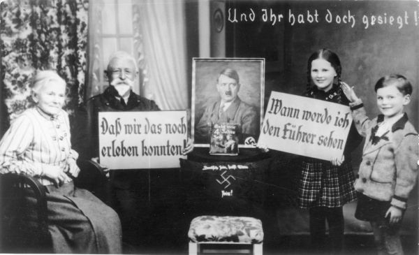 Großeltern und Enkel beim Posieren mit Propagandaschildern