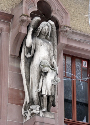 Schutzengel mit Mädchen über dem Eingangsportal der auf dem Klostergelände befindlichen Grundschule Lichtenthal.