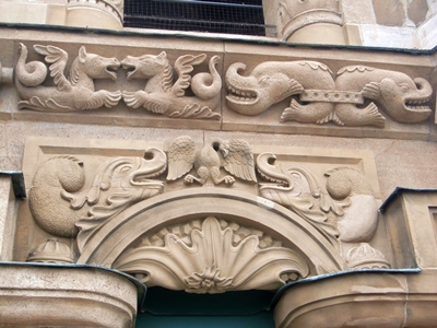 Bausymbolik am Turm: Der Adler als Wappentier der Reichsstadt, rechts und links von Ungeheuern bedroht