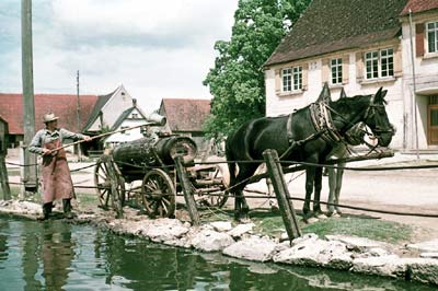 Wasserfuhrwerk mit Pferden vor einer Hüle 1957